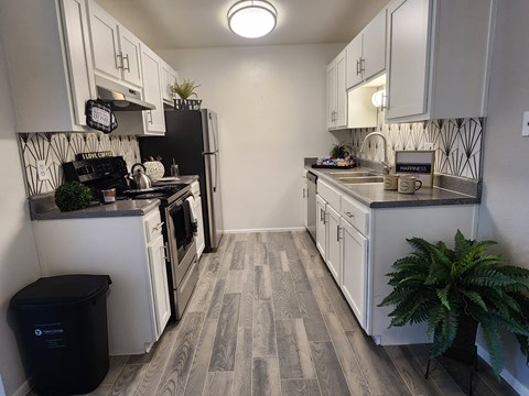 a kitchen with white cabinets and a stove and a refrigerator